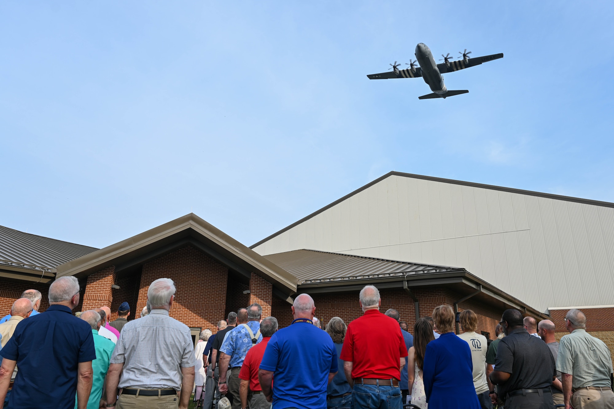 An aircraft flies over a ceremony.