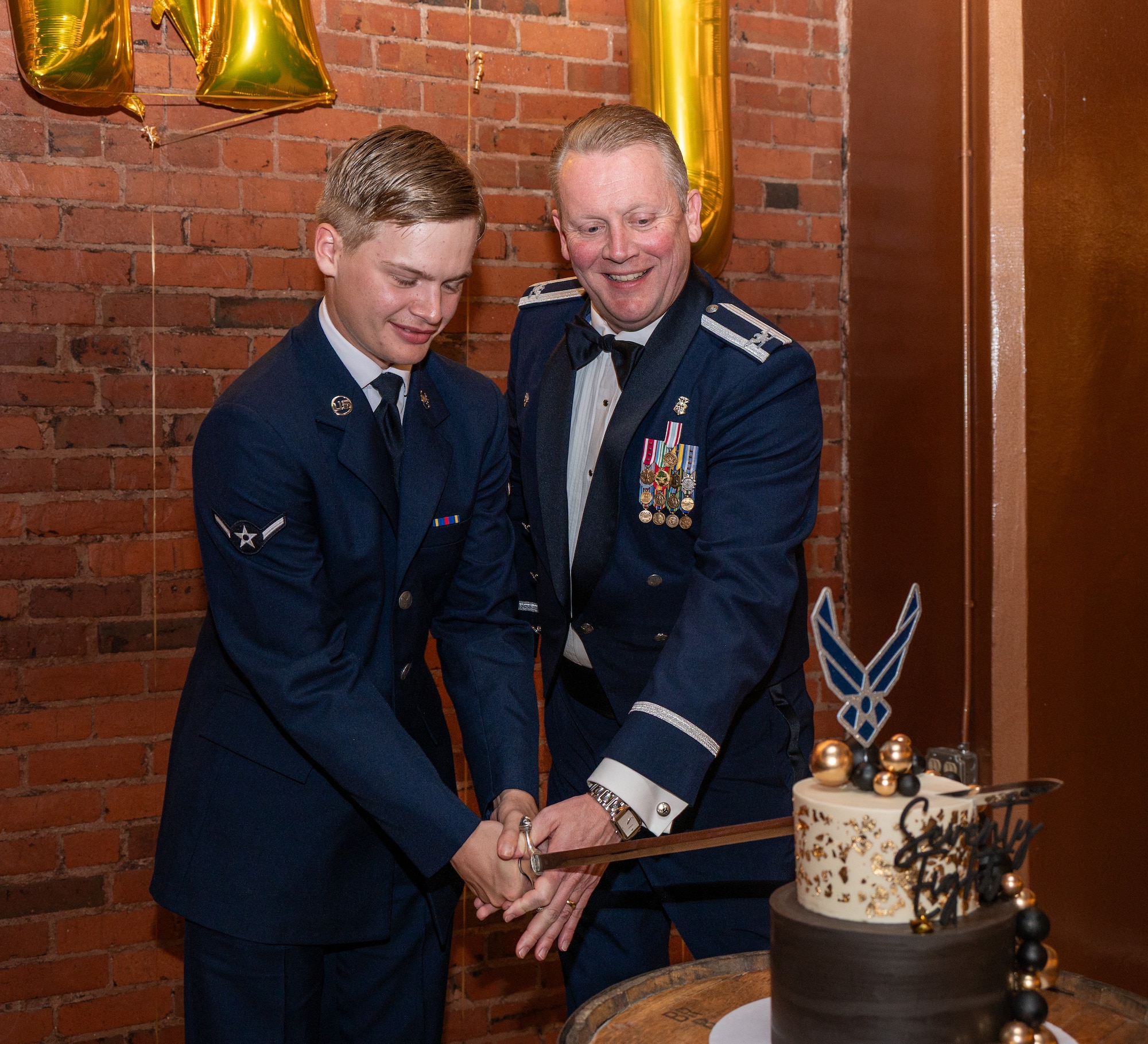 Two airmen cut a cake