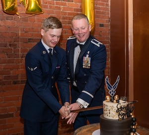 Two airmen cut a cake