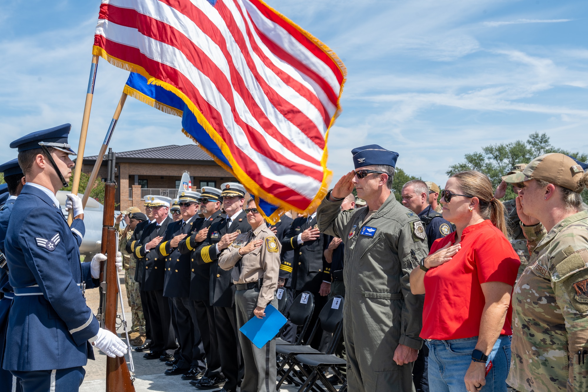 Audience stands as honor guard airmen presents colors.