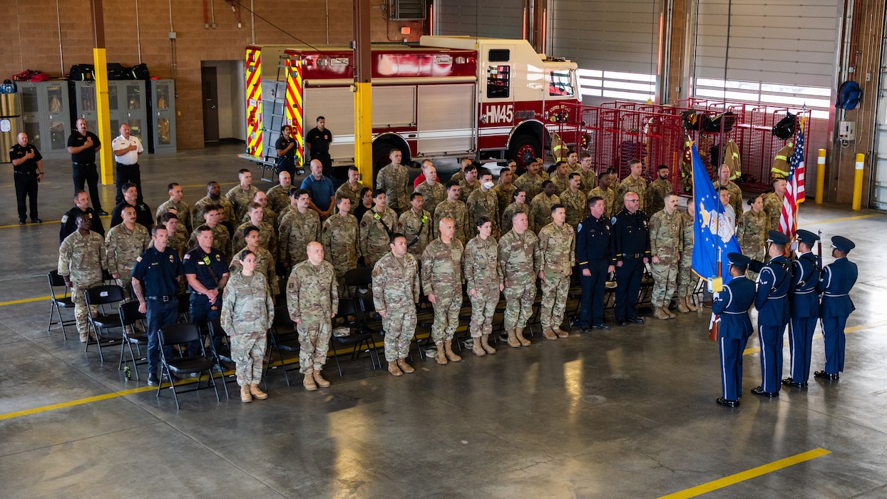 Attendees stand for the presentation of the colors