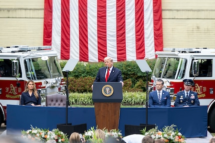 The president speaks at a podium as the defense secretary and chairman sit the right and the first lady on the left.