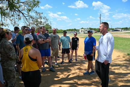 Col. Joshua Garrison, right, 960th Cyberspace Wing commander, addresses Airmen before a 5K run at the Medina Chapman Fitness Center on Joint Base San Antonio-Lackland, Texas Sep. 2, 2025.