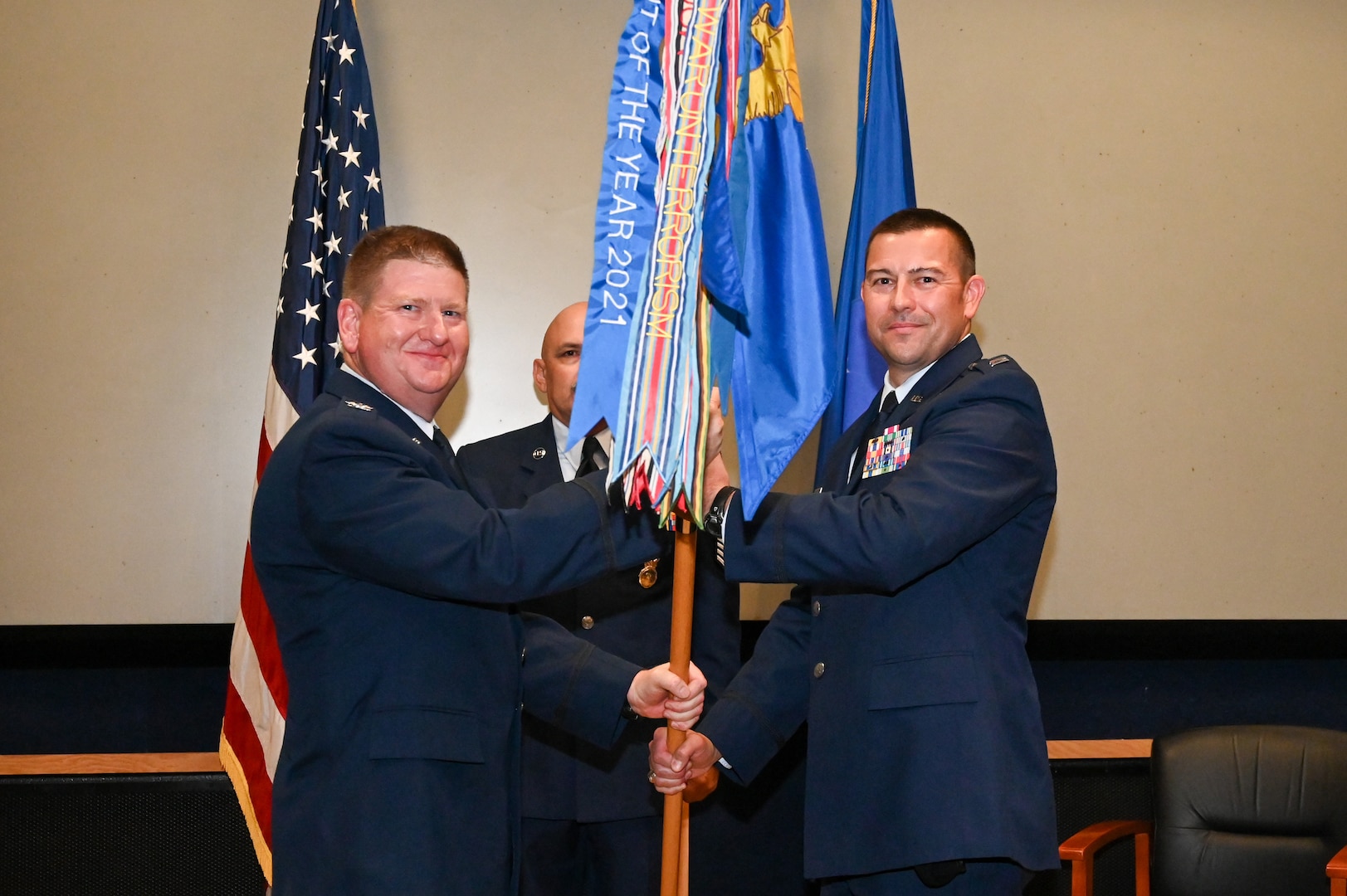 Col. Jeremy Patrick, 433rd Mission Support Group commander, presents the 433rd Security Forces Squadron guidon to Capt. Scott Bean, 433rd SFS commander, during an assumption of command ceremony at Joint Base San Antonio-Lackland, Texas, Sept. 6, 2025.