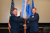 Col. Jeremy Patrick, 433rd Mission Support Group commander, presents the 433rd Security Forces Squadron guidon to Capt. Scott Bean, 433rd SFS commander, during an assumption of command ceremony at Joint Base San Antonio-Lackland, Texas, Sept. 6, 2025.