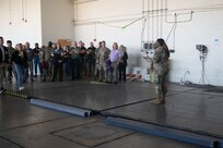 SSgt Mahmood, right, talks to a large group of civilian employers and military personnel in a hangar during a base tour