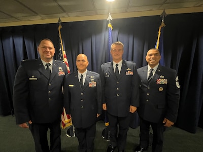 Four USAF members wearing blues stand together