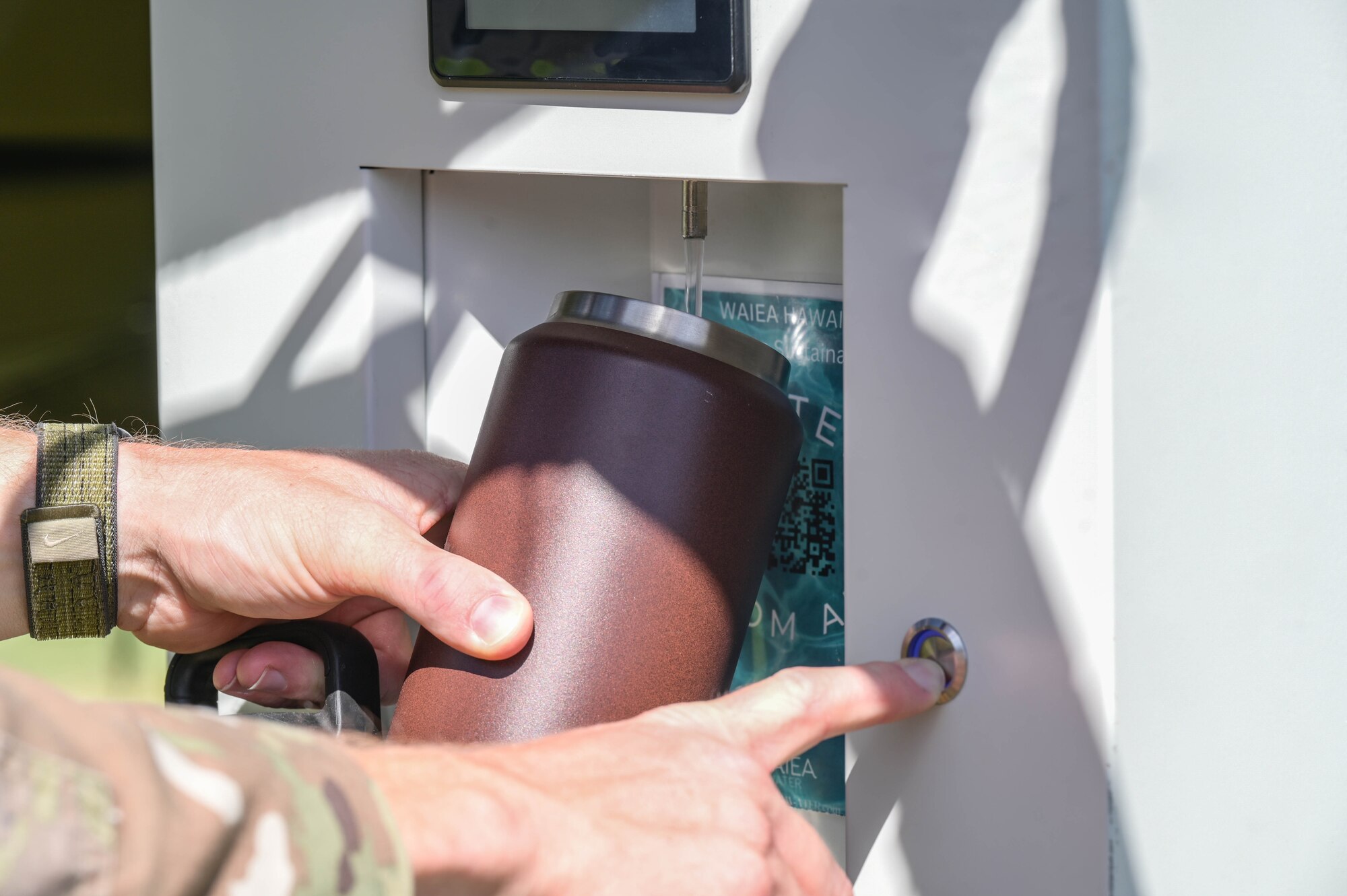 Airman pressing button to receive water from a generator.