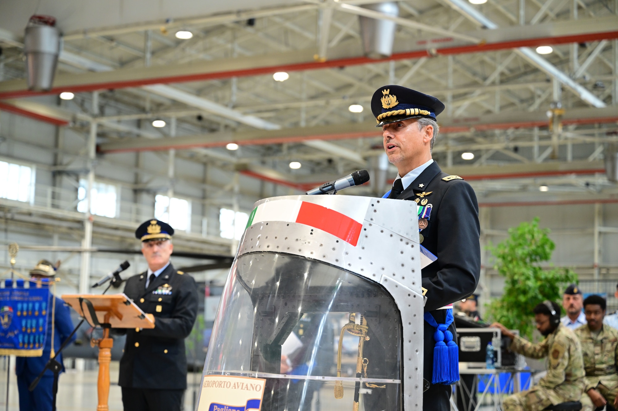 Members of the Italian Air Force speak at a podium.