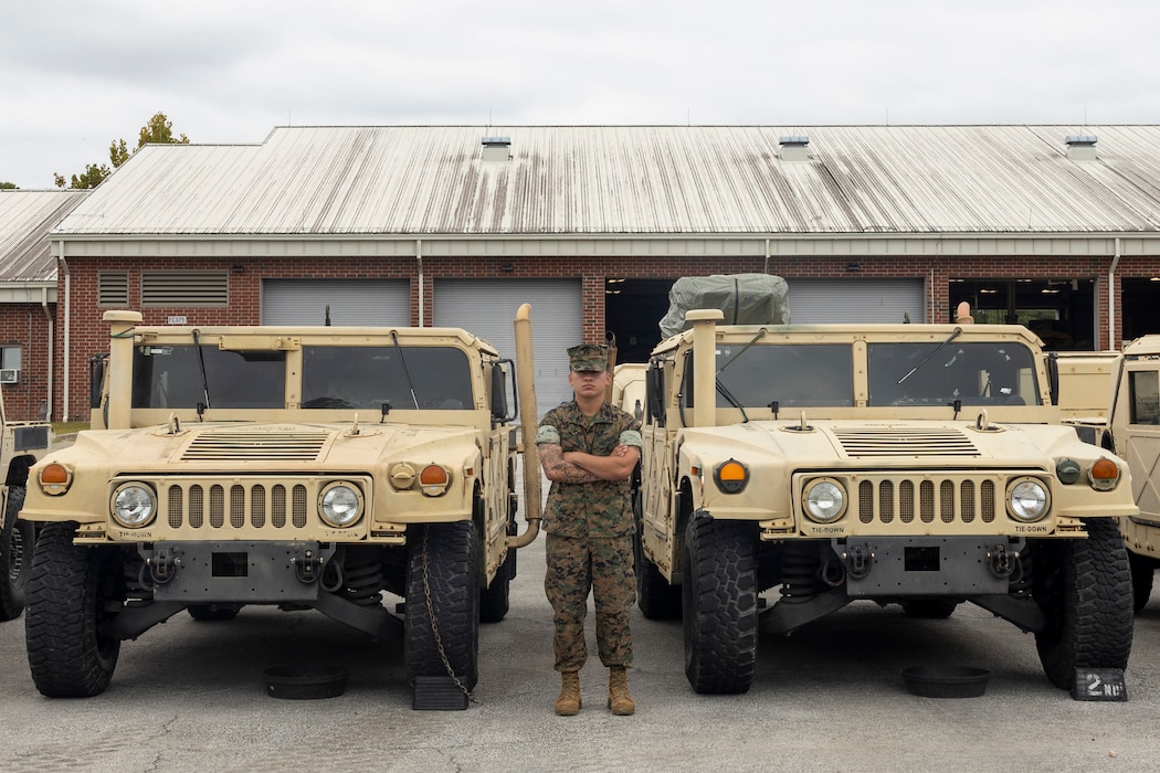 U.S. Marine Corps Cpl. Luis Garcia, a motor transport operator with Combat Logistics Battalion 2, Combat Logistics Regiment 2, 2nd Marine Logistics Group, poses for a photo with high mobility multipurpose wheel vehicles at Marine Corps Base Camp Lejeune, North Carolina, Sept. 9, 2025. Garcia was nominated as the 2nd MLG Warrior of the Week by his command due to his superior leadership, technical mastery, and unwavering dedication to mission accomplishment. Garcia is a native of Wimauma, Florida. (U.S. Marine Corps photo by Lance Cpl. Isabella Ramos)