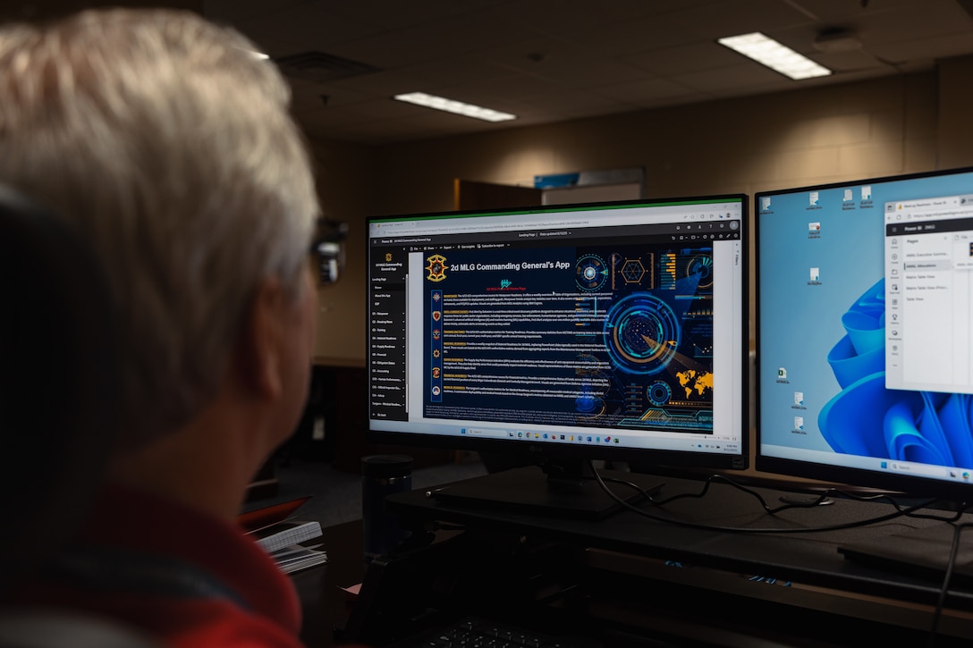 Mr. Scott Yoder with the Command Data Analytics Office, 2nd Marine Logistics Group, looks at a screen showing the 2nd MLG Commanding General App at Marine Corps Base Camp Lejeune, North Carolina, Aug. 12, 2025. The Command Data Analytics Office, first formed at 2nd MLG, aims to improve the way that 2nd MLG analyzes and implements digital transformation and ethical artificial intelligence use into enabled decision making for its customers. (U.S. Marine Corps photo by Lance Cpl. Brady V. Hathaway)