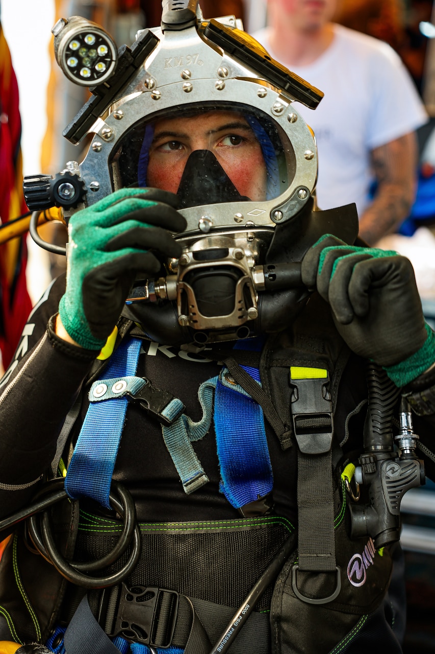 NAVAL STATION NORFOLK, July 17, 2025 – Navy Diver 2nd Class Austin Good, assigned to Explosive Ordnance Disposal Mobile Unit 6, performs surface checks on his KM-97 prior to diving on the amphibious assault ship USS Iwo Jima (LHD 7) while conducting underwater ship husbandry work with the Mid-Atlantic Regional Maintenance Center (MARMC) team. MARMC’s mission is essential to maintaining submarines, surface ships, and aircraft carriers through a series of complex underwater repairs and maintenance tasks, ensuring the fleet remains safe, ready, and mission-capable. (U.S. Navy photo by Mass Communication Specialist 2nd Class Imani Nave Bloodsaw)
