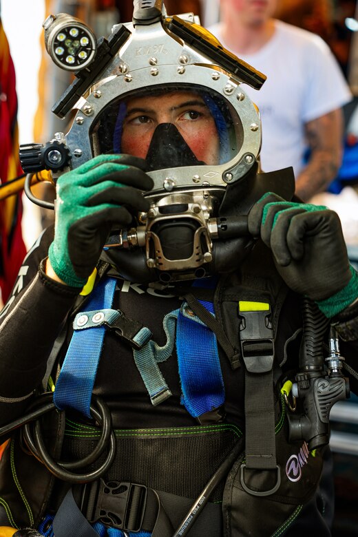 NAVAL STATION NORFOLK, July 17, 2025 – Navy Diver 2nd Class Austin Good, assigned to Explosive Ordnance Disposal Mobile Unit 6, performs surface checks on his KM-97 prior to diving on the amphibious assault ship USS Iwo Jima (LHD 7) while conducting underwater ship husbandry work with the Mid-Atlantic Regional Maintenance Center (MARMC) team. MARMC’s mission is essential to maintaining submarines, surface ships, and aircraft carriers through a series of complex underwater repairs and maintenance tasks, ensuring the fleet remains safe, ready, and mission-capable. (U.S. Navy photo by Mass Communication Specialist 2nd Class Imani Nave Bloodsaw)