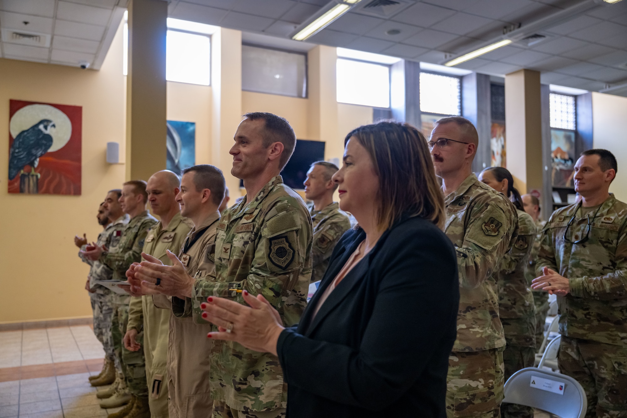 Members of the 379th Air Expeditionary Wing applaud during an assumption of command ceremony within the U.S. Central Command area of responsibility, Sept. 12, 2025. The ceremony saw Brig. Gen. Daniel Clayton assume command of the largest wing in the AOR. (U.S. Air Force photo by Senior Airman Amanda Jett)