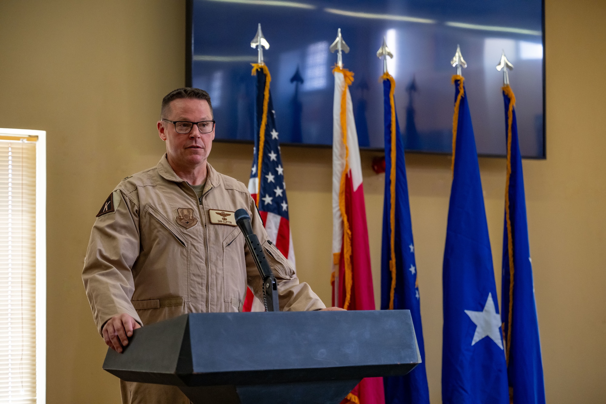 U.S. Air Force Brig. Gen. Daniel Clayton, 379th Air Expeditionary Wing incoming commander, gives a speech during the 379th AEW Assumption of Command Ceremony within the U.S. Central Command area of responsibility, Sept. 12, 2025. The assumption of command formally announces the new commanding officer and publicly recognizes their leadership over the unit. (U.S. Air Force photo by Senior Airman Amanda Jett)