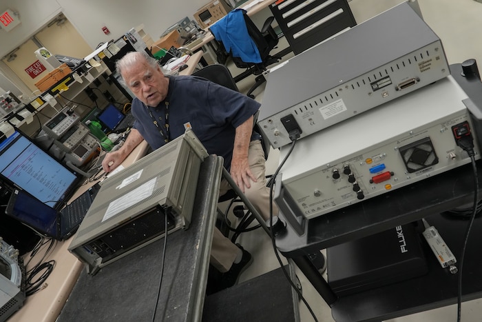 Man compares one radio controller against a standard