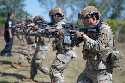 Airmen pointing rifles in formation