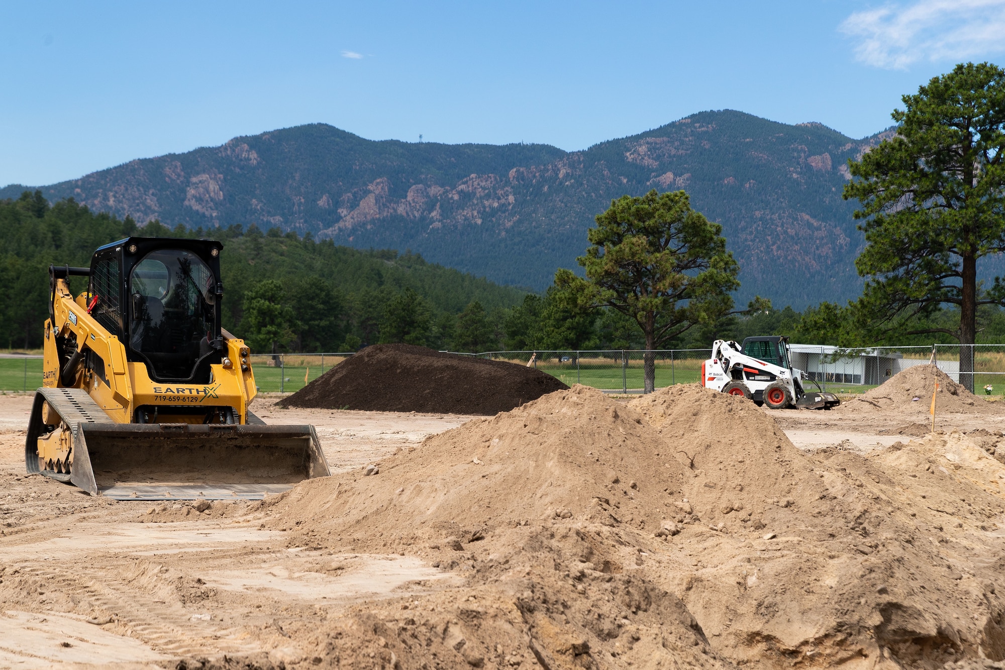 Photo of construction equipment moving piles of dirt