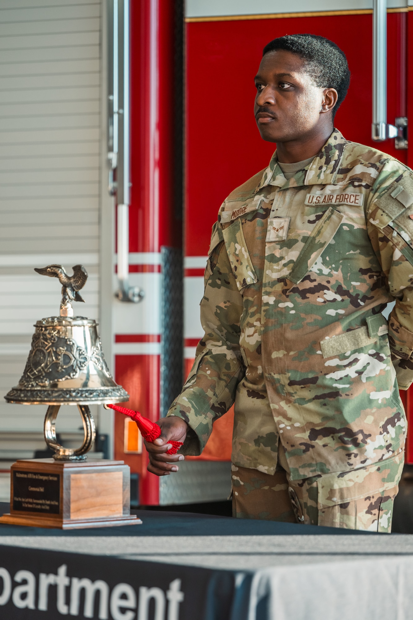 An Airman rings a ceremonial bell.