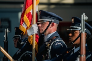 An Airman holds up an American flag up to his face.