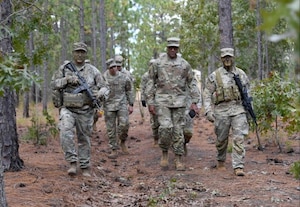 Soldiers walk in the forest.