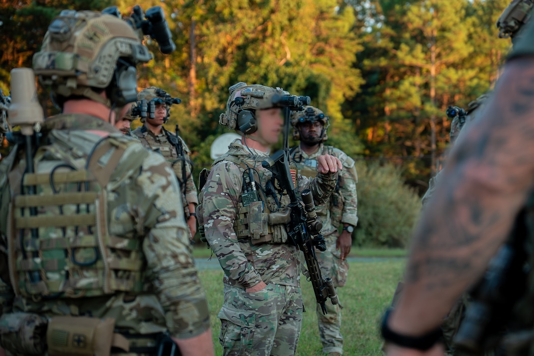 U.S. Soldiers assigned to 3rd Special Forces Group (Airborne), alongside Airman security forces with Air National Guard (ANG), and 824th Base Defense Squadron participate in a sand table brief during Sage Eagle exercise 25-4 on Fort A.P. Hill, Virginia, August 30, 2025. Every year, Sage Eagle exercise tests the agility, precision, and combat readiness of 3rd Special Forces Group (Airborne) Soldiers alongside partner forces as they prepare to face the challenges of real-world missions. (U.S. Army photo taken by Sgt. Edward Randolph) (This photo has been altered for security purposes by blurring to protect the service member's identity)