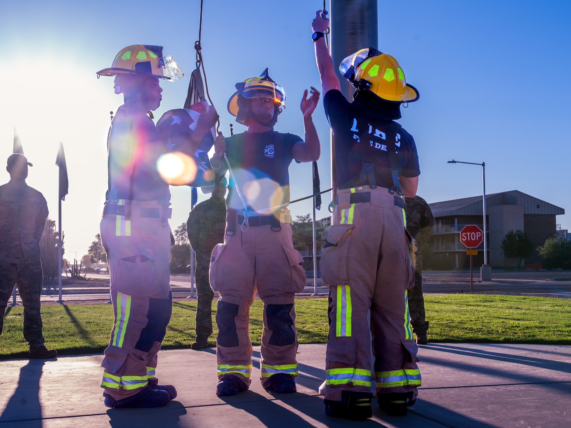 U.S. Air Force Airmen and firefighters assigned to the 56th Civil Engineer Squadron participate in a flag is raising during a 9/11 memorial event, Sept. 11, 2025, at Luke Air Force Base, Arizona.