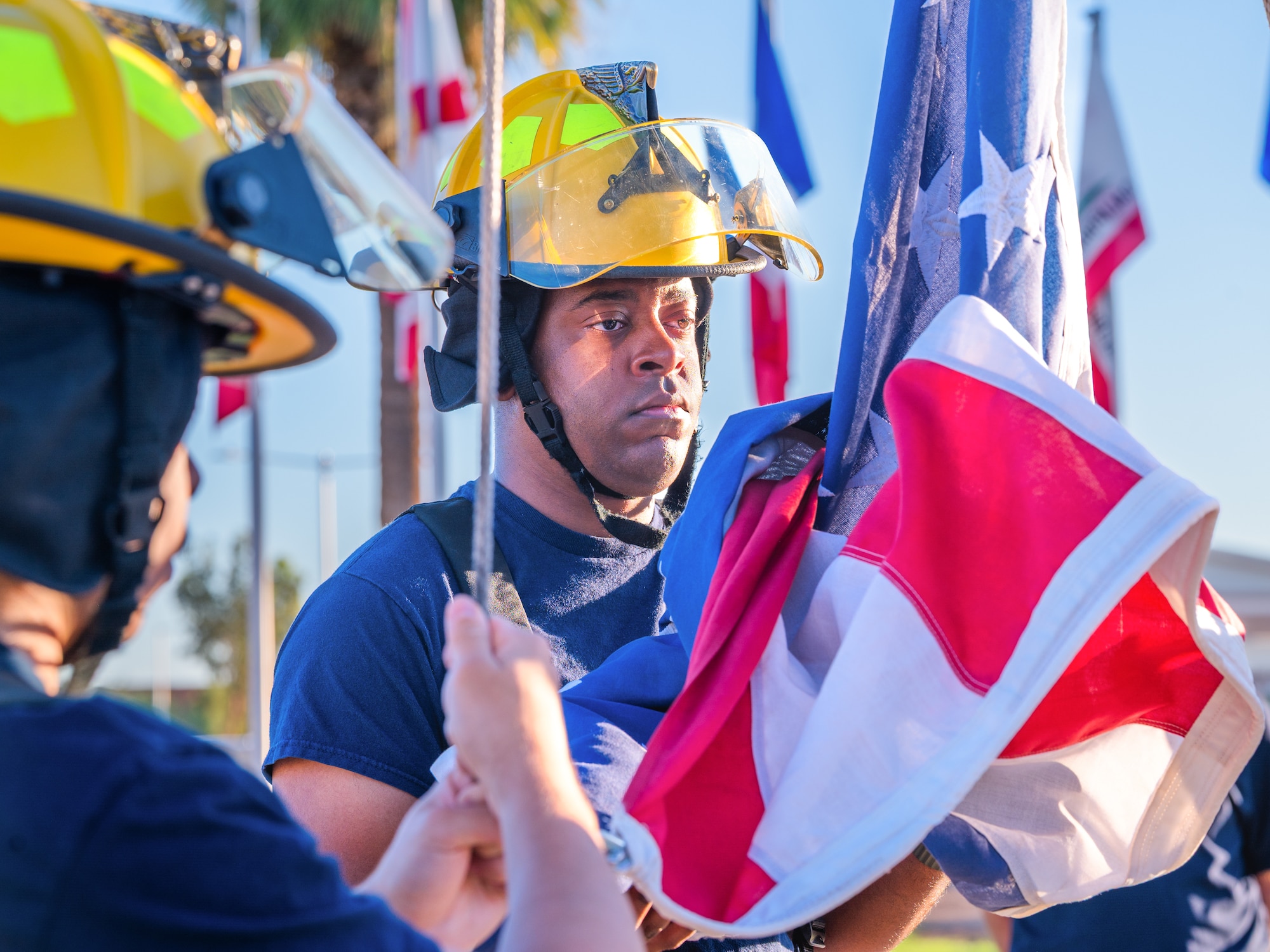 U.S. Air Force Airman 1st Class Daniel Pippins, 56th Civil Engineer Squadron firefighter, participates in a flag is raising during a 9/11 memorial event, Sept. 11, 2025, at Luke Air Force Base, Arizona.
