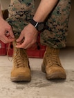 A Marine laces up a pair of boots