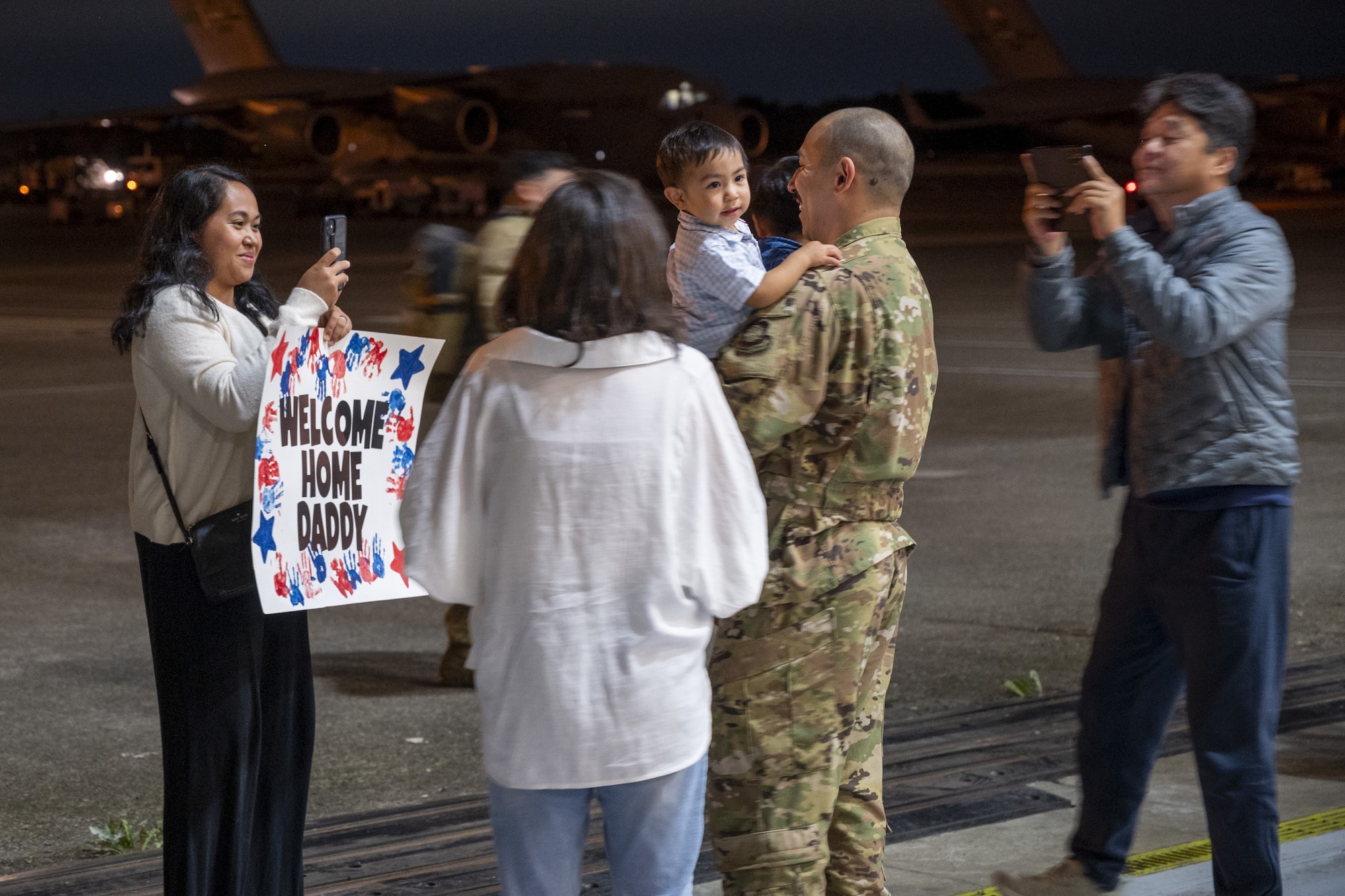 U.S. Air Force Capt. Jooney Jung, 7th Airlift Squadron pilot, reunites with his family during the 7th Expeditionary Airlift Squadron’s redeployment to Joint Base Lewis-McChord, Washington, Sept. 7, 2025.