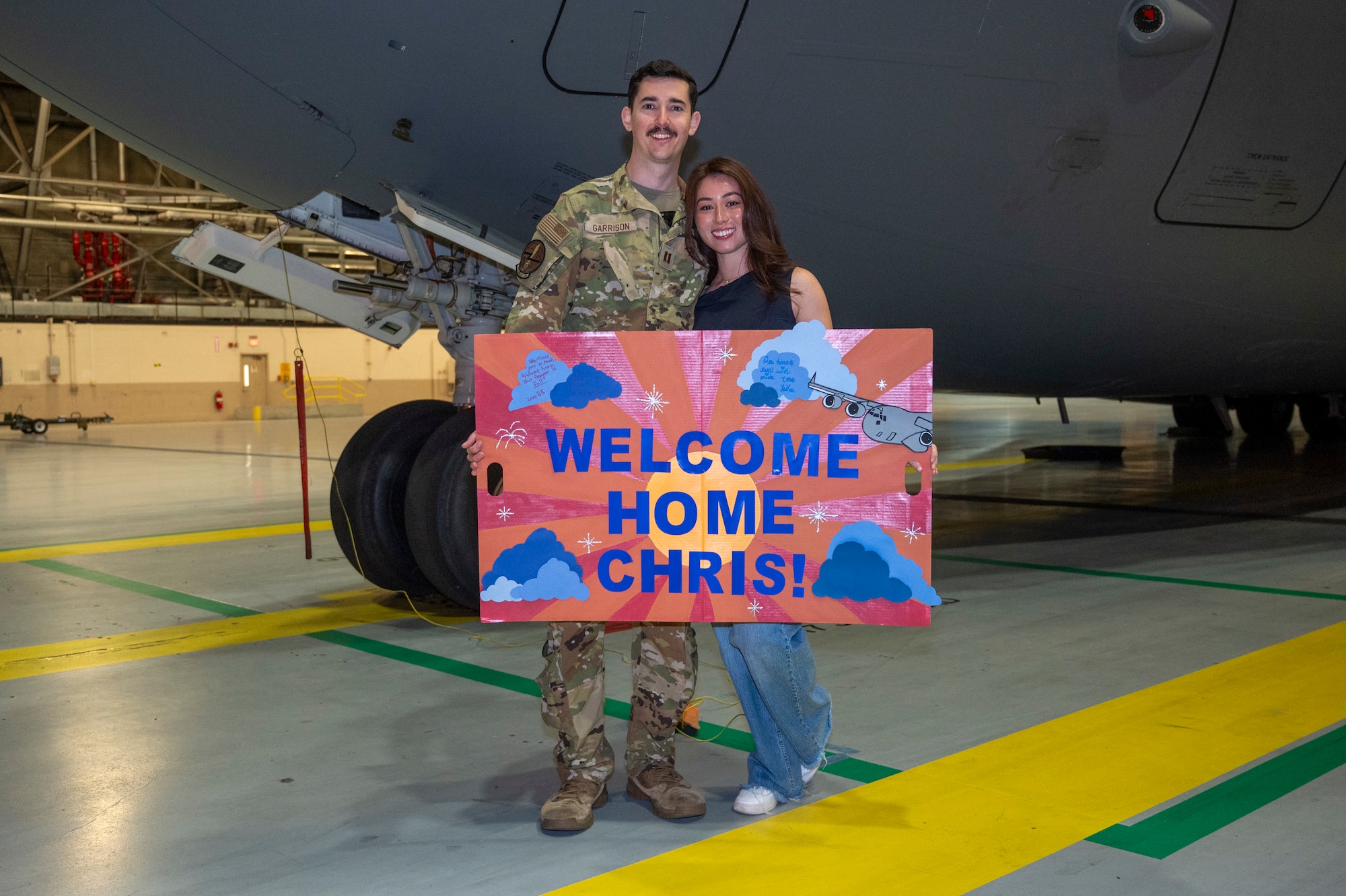 U.S. Air Force Capt. Chris Garrison, 7th Airlift Squadron pilot, stands with his spouse during the 7th Expeditionary Airlift Squadron’s redeployment to Joint Base Lewis-McChord, Washington, Sept. 7, 2025.