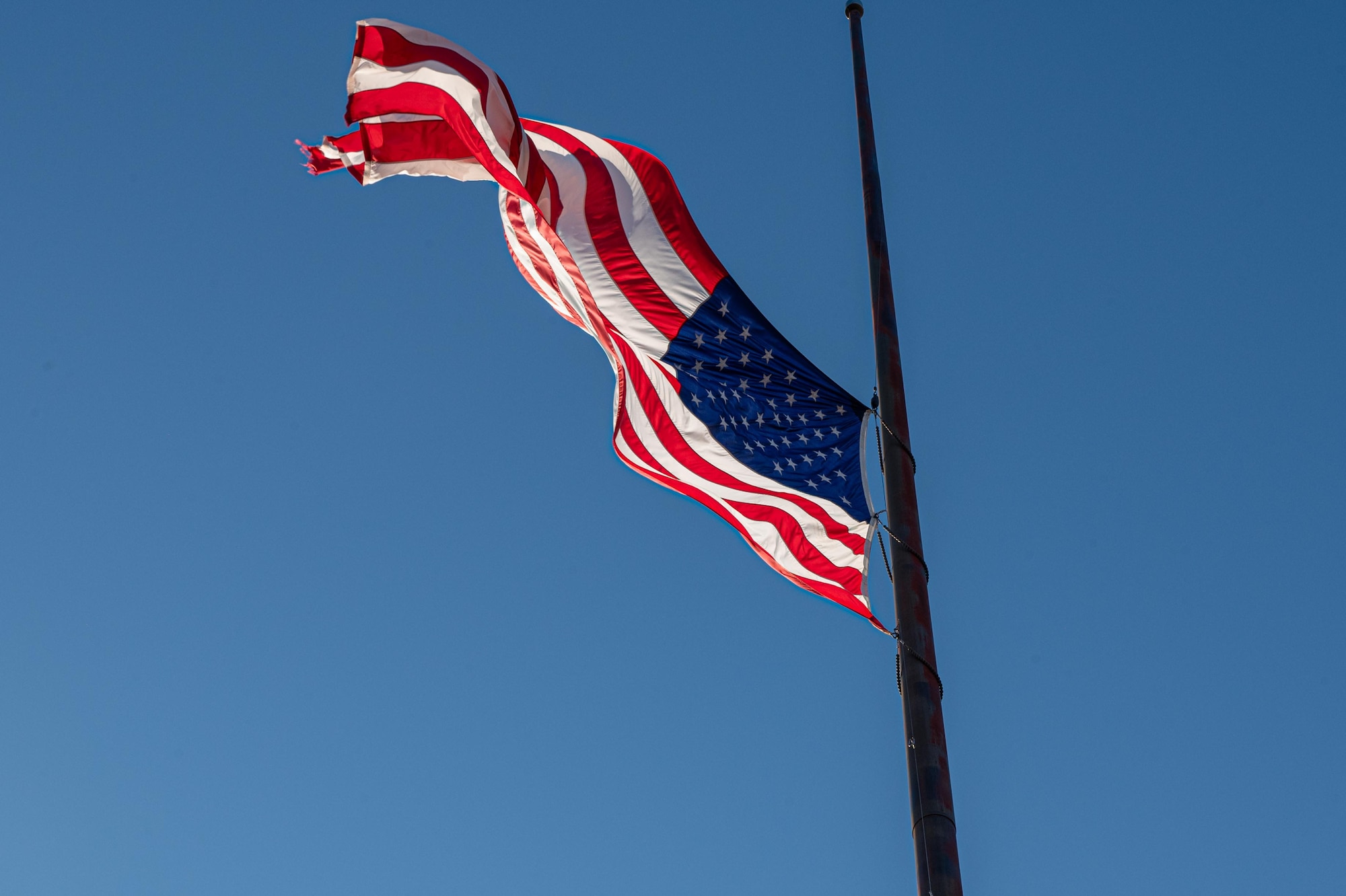 The United States flag flies at half-staff during a 9/11 memorial at Dyess Air Force Base, Texas, Sept. 11, 2025. Dyess hosted the ceremony to honor the thousands of lives taken during the attacks on September 11, 2001. (U.S. Air Force Photo by Airman 1st Class Adrien Tran)