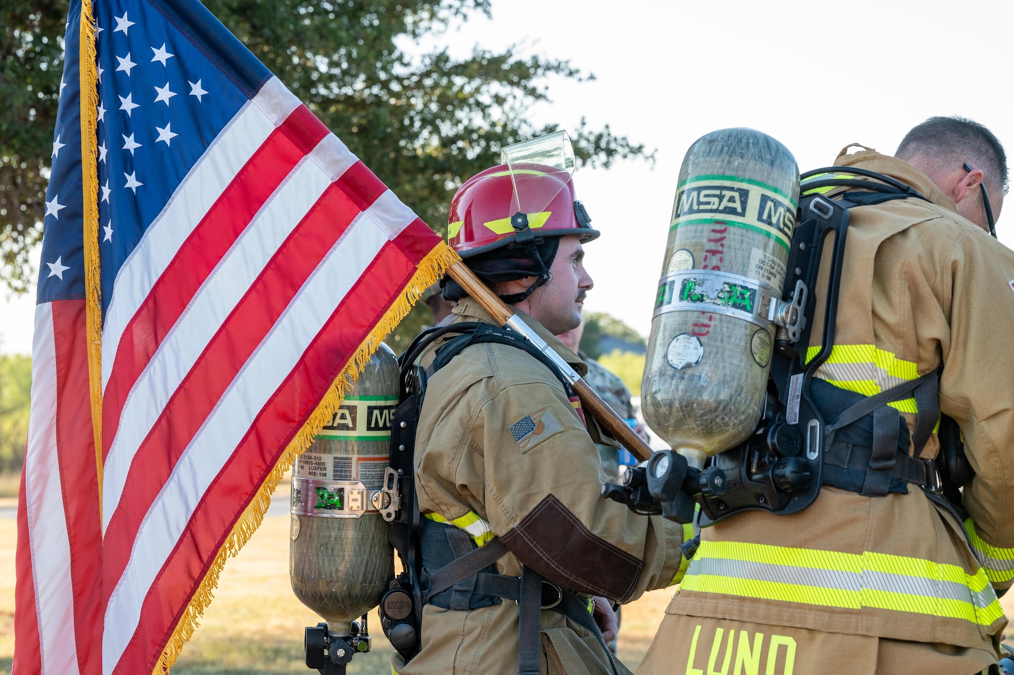 U.S. Air Force Tech. Sgt. Jared Williams, 7th Civil Engineer Squadron noncommissioned officer in charge of dispatch, carries the U.S. flag during a 9/11 memorial ruck at Dyess Air Force Base, Texas, Sept. 11, 2025. Dyess came together for a 9/11 memorial and ruck to honor the spirit of sacrifice made by first responders, members of the armed forces and community members in the days and years that followed the attacks. (U.S. Air Force photo by Airman 1st Class Adrien Tran)