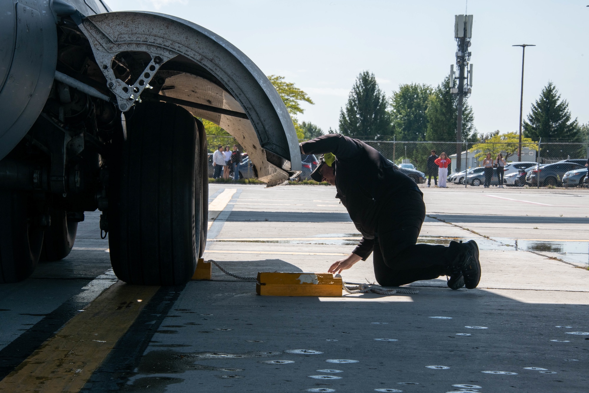 person on the ground puts chock under aircraft tire
