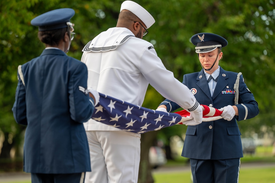 U.S. Air Force 35th Fighter Wing and U.S. Navy Naval Air Facility Misawa Honor Guard fold the U.S. flag during a 9/11 ceremony at Misawa Air Base, Japan. Sept. 11, 2025. The folding of the flag served as a symbol of respect for th