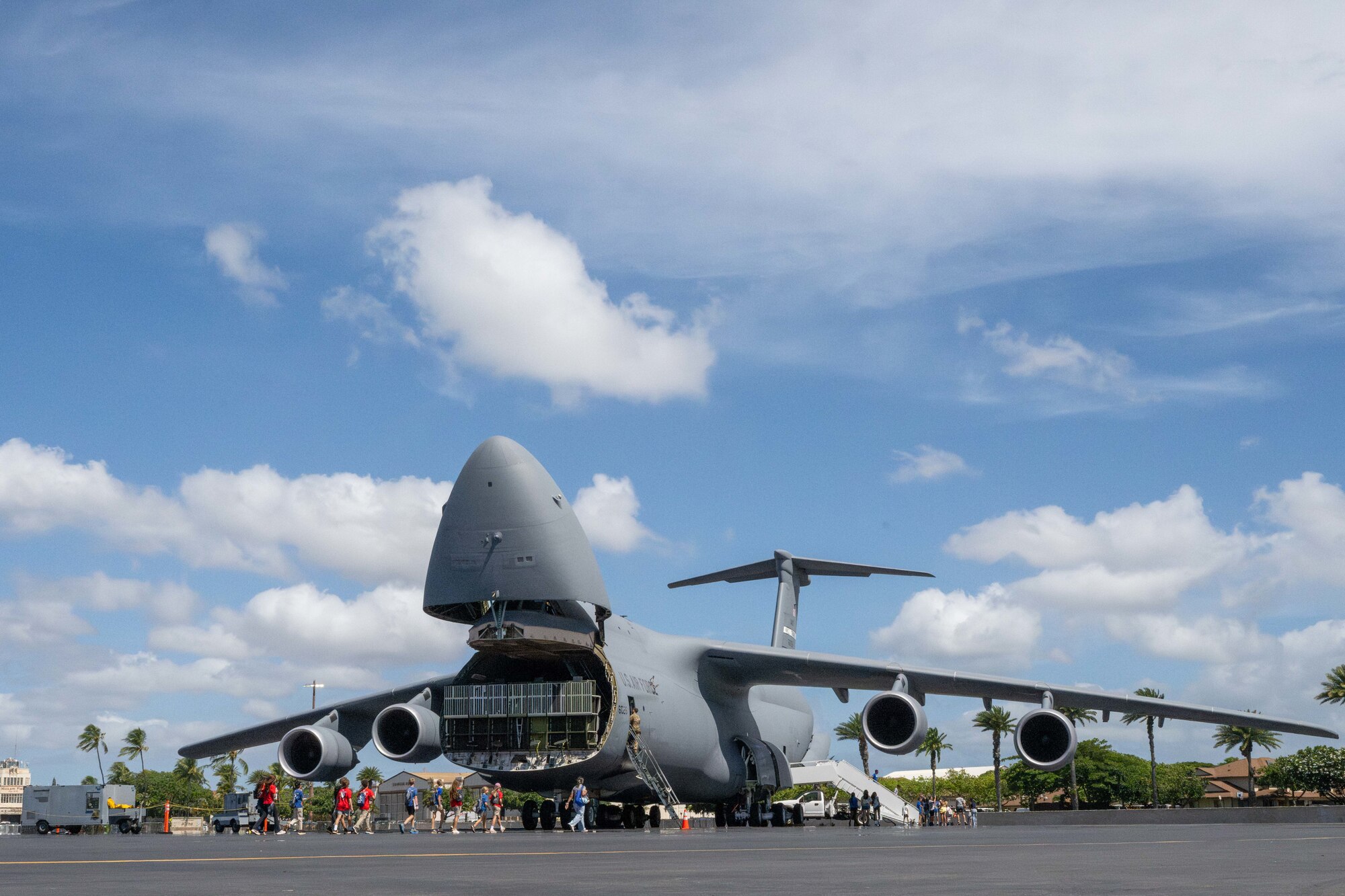 Students from across Oahu walk towards a C-5 Galaxy on the flightline of Joint Base Pearl Harbor-Hickam, Hawaii, during the Wings of Aloha Student Expo.