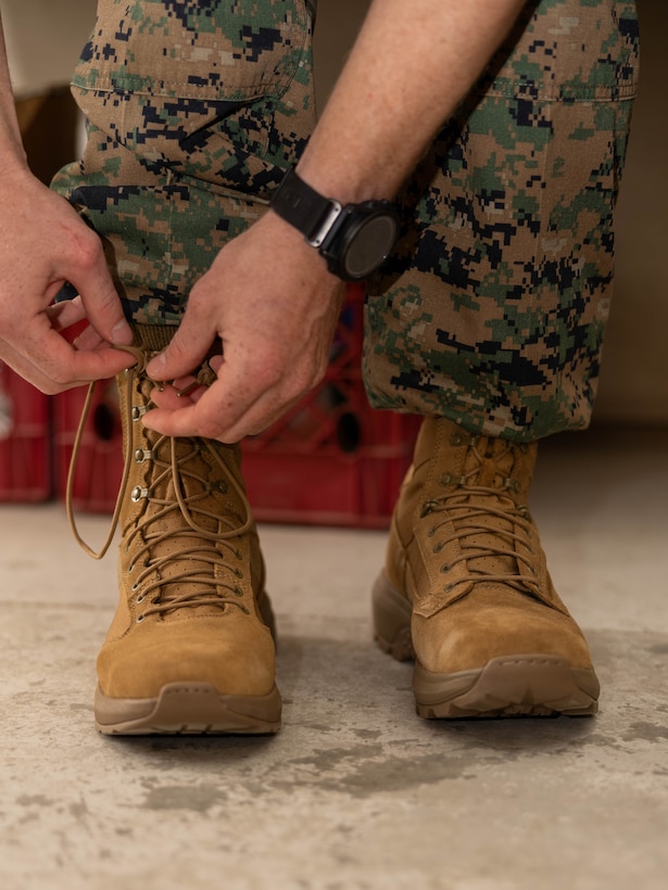 A Marine laces up a pair of boots