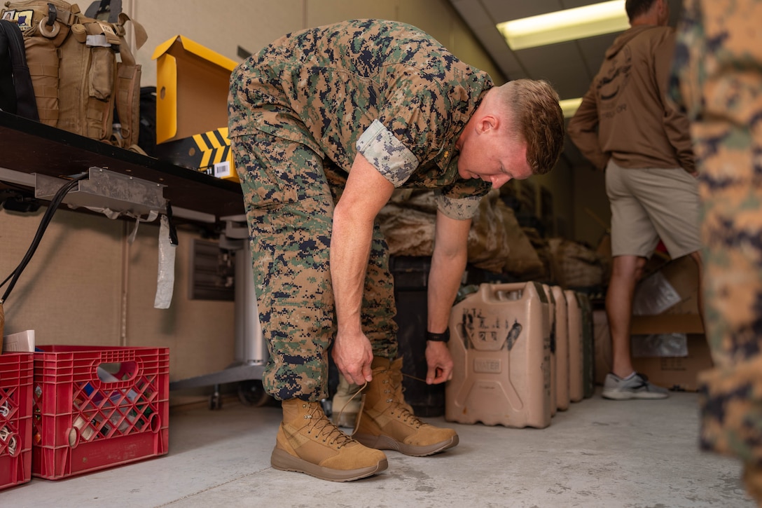 A Marine laces up a pair of boots as part of the Optional Boot Program
