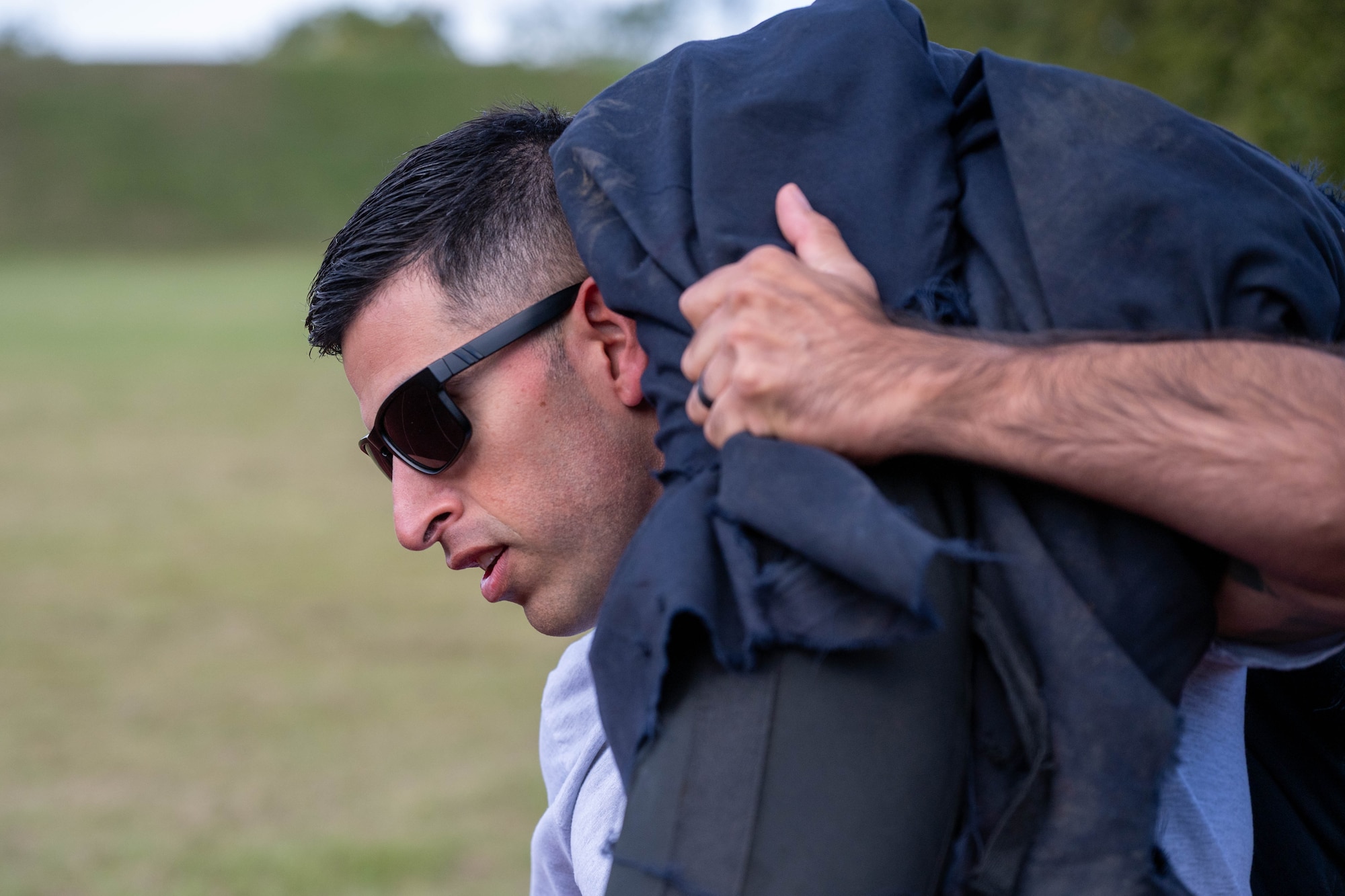 An Airman carries a dummy during a combat fitness challenge