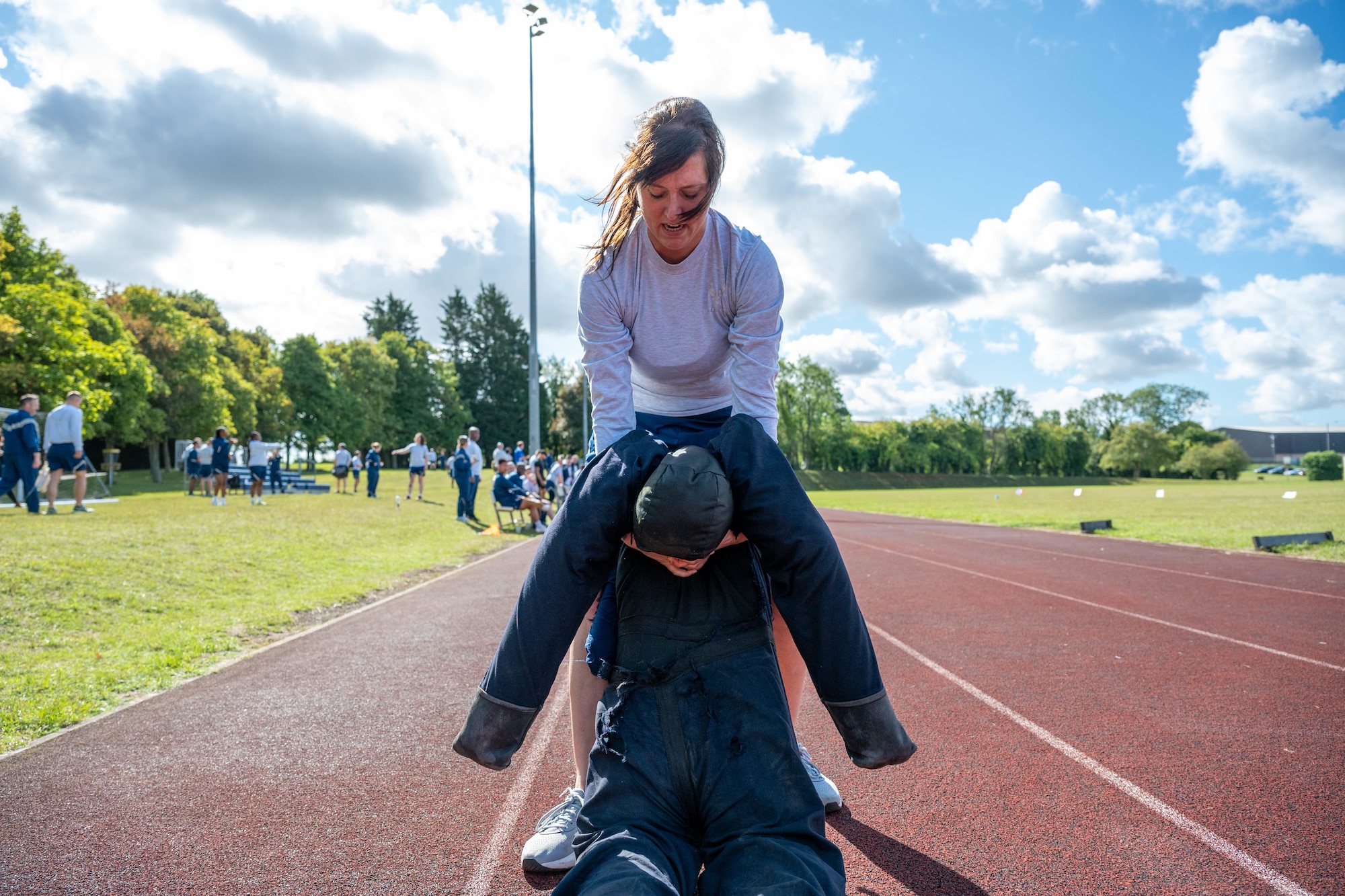 An Airman drags a dummy across the track