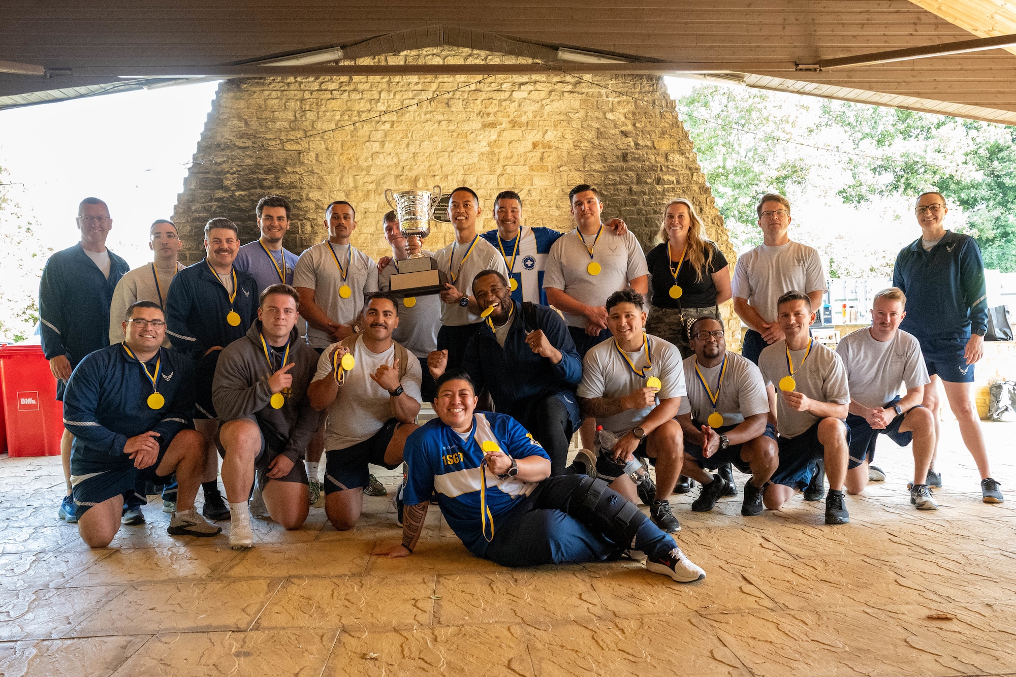 Airmen pose with medals and a trophy