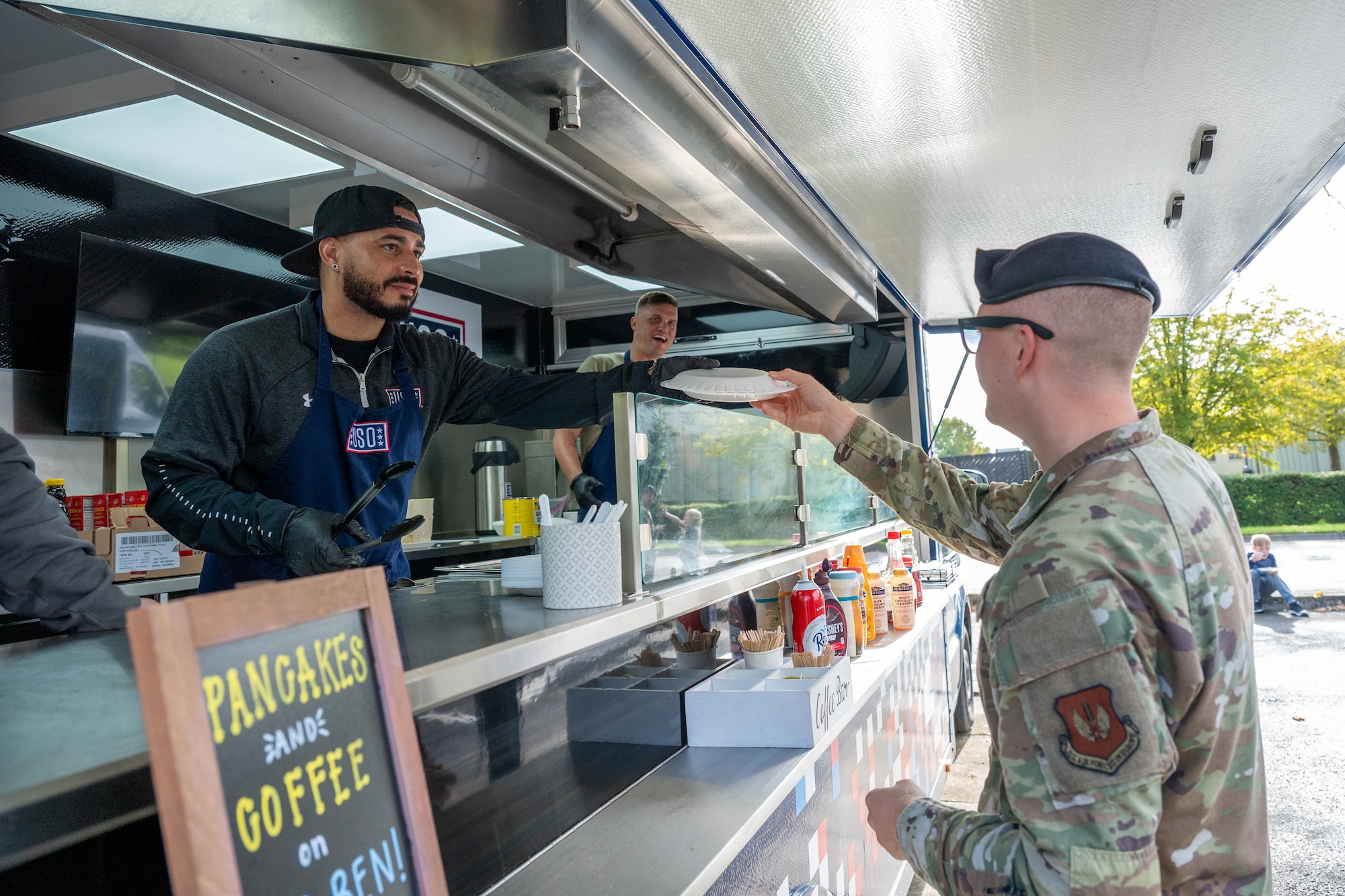 An Airman receives pancakes from the USO’ “Big Ben” food truck