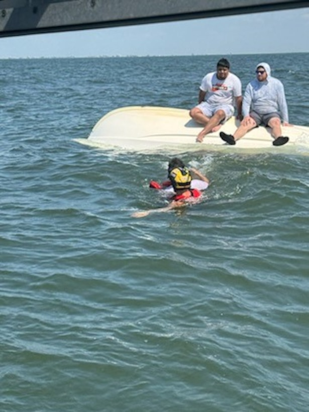 The rescues swimmer assisting of the three in the water.