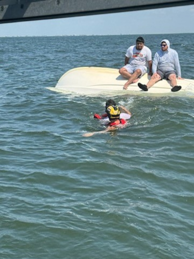 The rescues swimmer assisting of the three in the water.