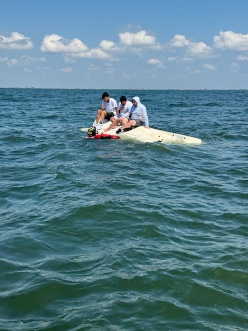 The rescue swimmer approaching the three.