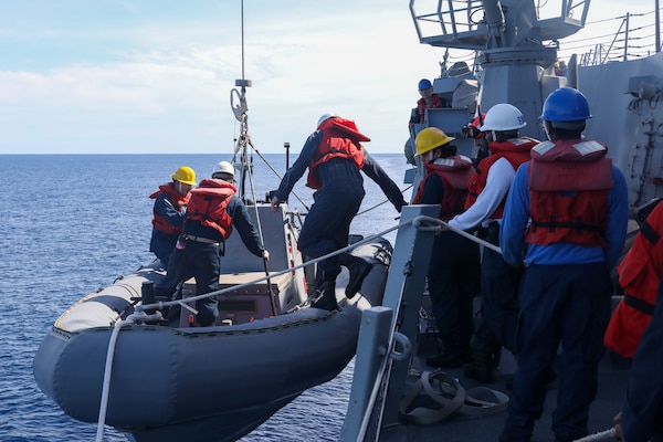 Sailors aboard the Arleigh Burke-class guided-missile destroyer USS John Finn (DDG 113) lower a rigid-hull inflatable boat during a small boat operation during Maritime Cooperative Activity with the Osumi-class tank landing ship JS Osumi (LST-4001) and the Jose Rizal-class frigate BRP Jose Rizal (FF-150) in the South China Sea, Sept. 13.