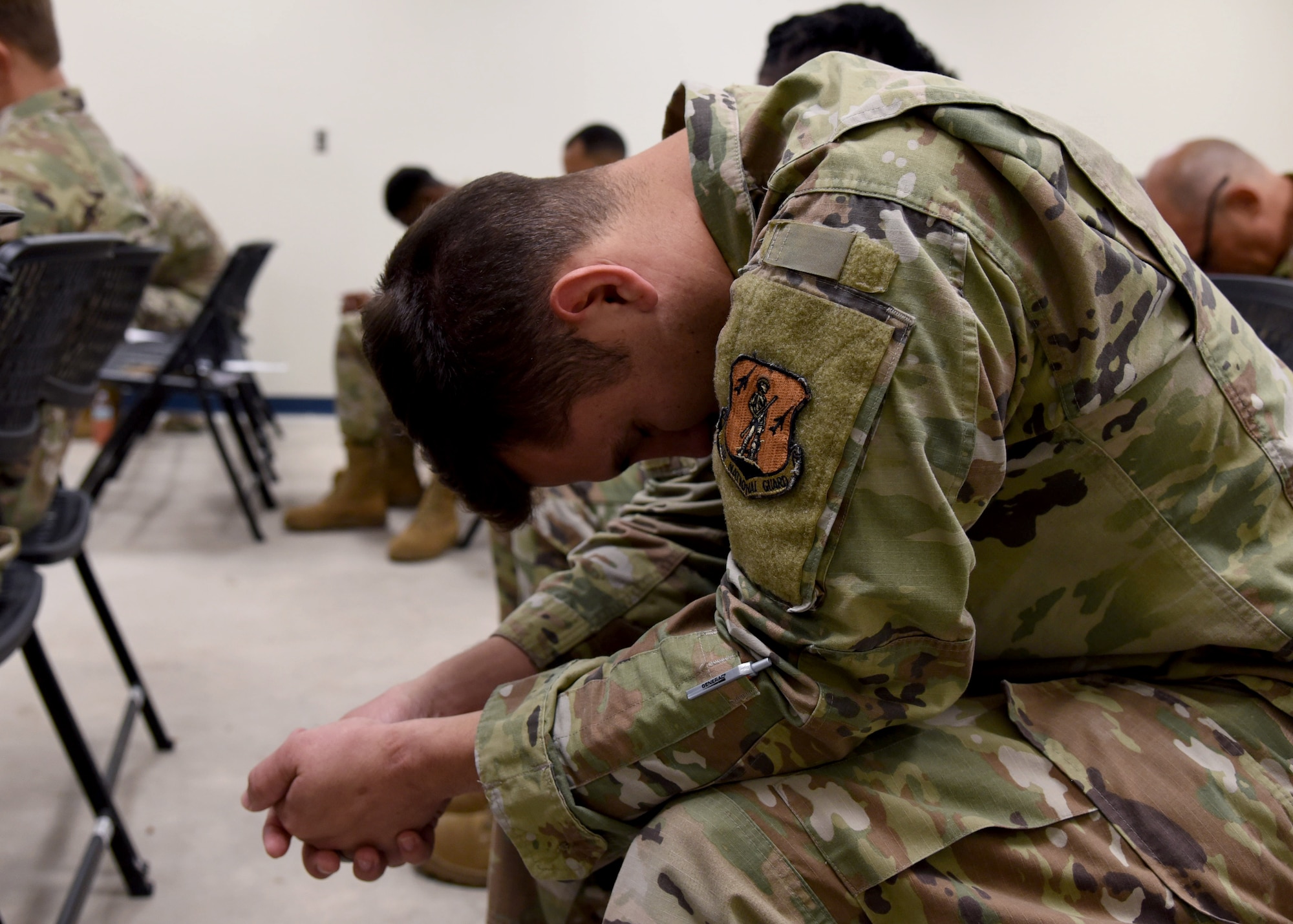 A U.S. Air Force Airman with the 117th Air Refueling Wing bows their head during a prayer led by a chaplain on Sept. 14, 2025, at Sumpter Smith Joint National Guard Base, Alabama.