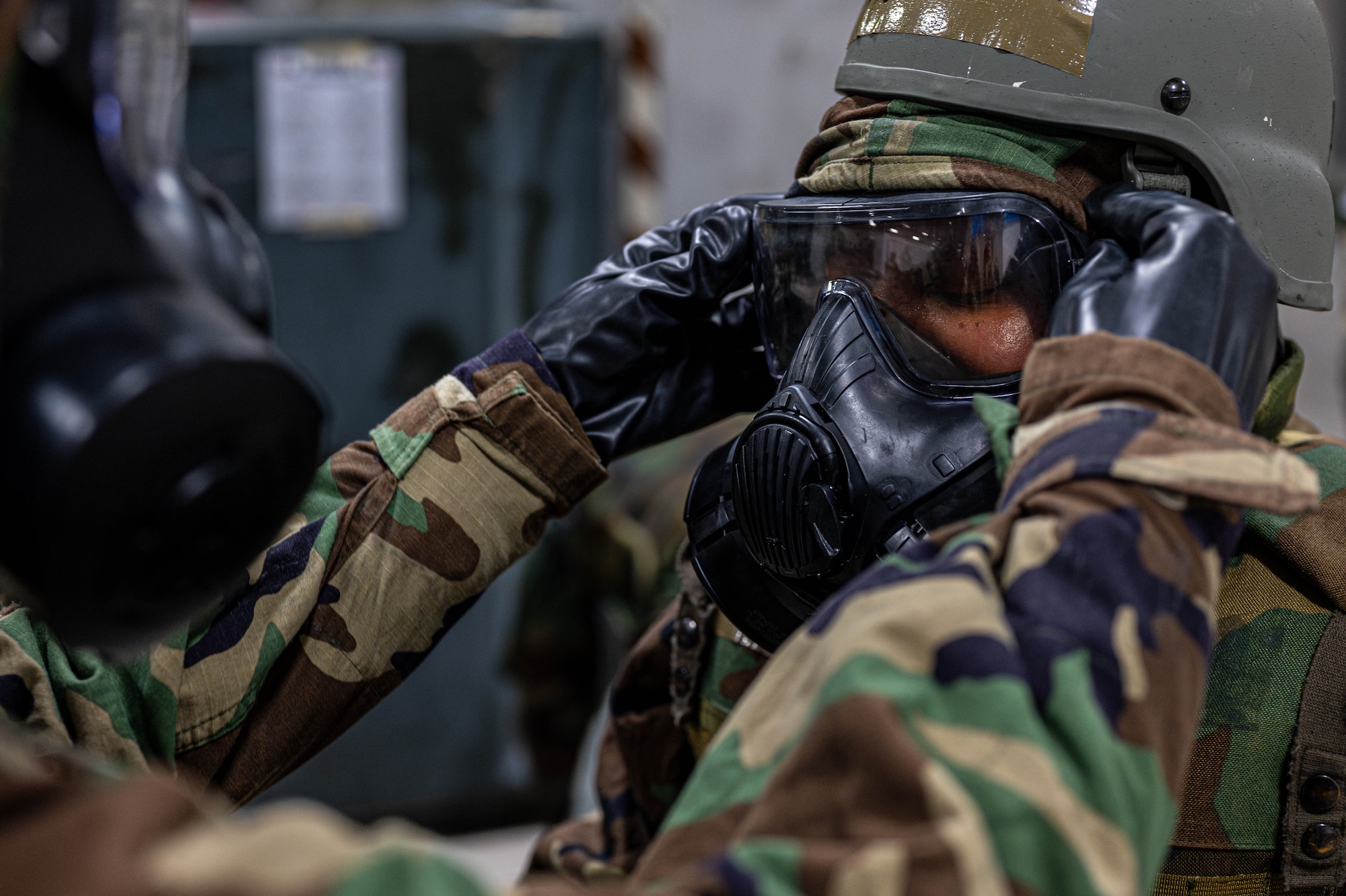 U.S. Air Force Airmen assigned to the 18th Wing, perform “buddy checks” during a chemical, biological, radiological and nuclear defense course at Kadena Air Base, Japan, Sept. 4, 2025. Airmen perform buddy checks to ensure protection and rely on a second set of eyes and hands to verify the gear is sealed correctly and fully operational. (U.S. Air Force photo by Airman Nathaniel Jackson)