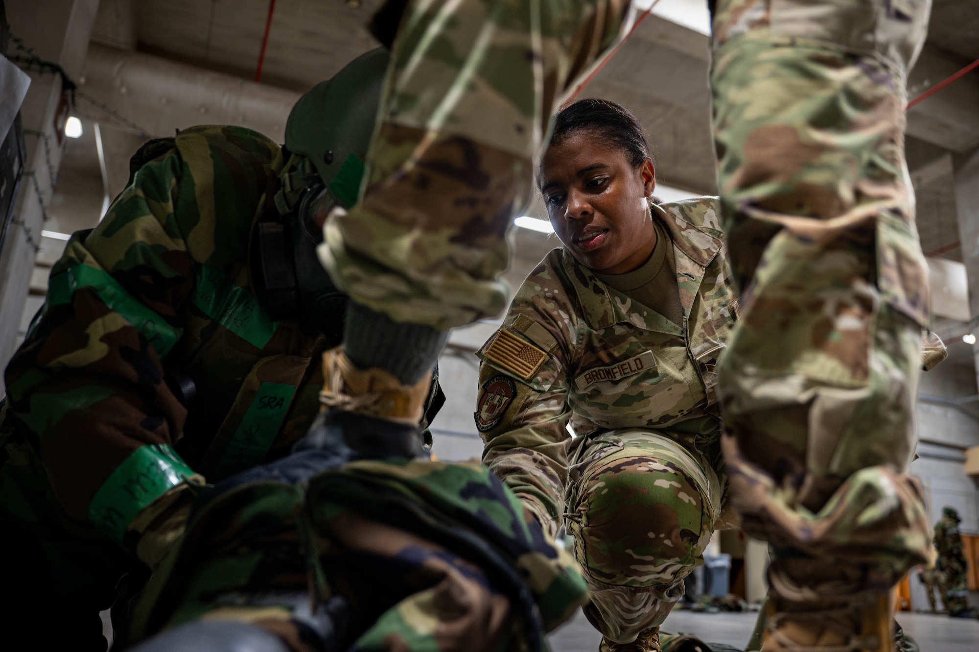 U.S. Air Force Senior Airman Shadae Bromfield, 18 Civil Engineer Squadron emergency management journeyman, helps Airmen remove gear during a chemical, biological, radiological and nuclear defense course at Kadena Air Base, Japan, Sept. 4, 2025. In emergency management, CBRN specialists perform response operations to support critical missions, ensuring the safety and security of personnel and equipment. (U.S. Air Force photo by Airman Nathaniel Jackson)