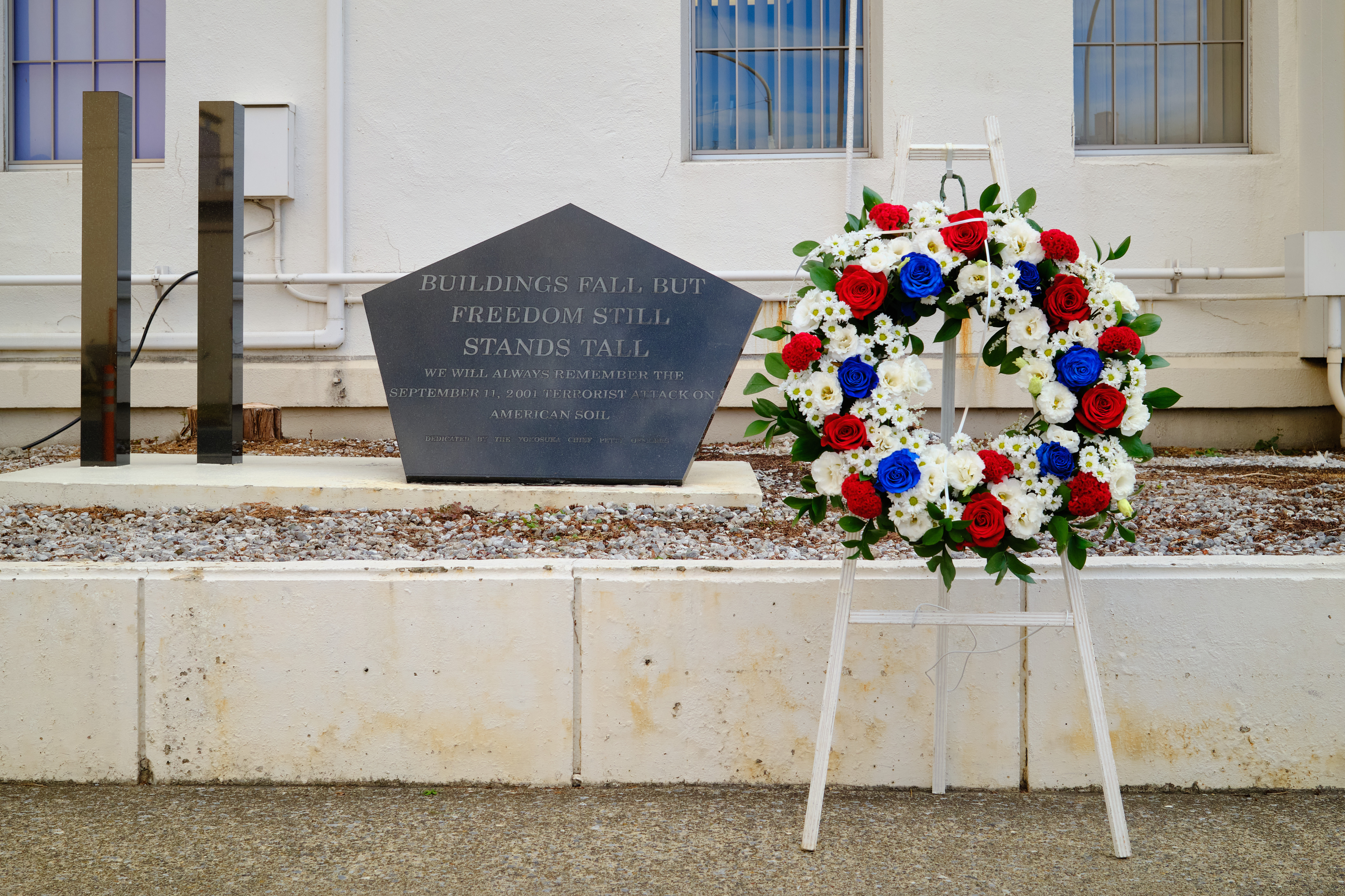 A wreath stands next to the Commander, Fleet Activities Yokosuka 9/11 Memorial outside the CPO Club Sept. 11, 2025.